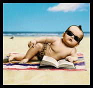 baby wearing sunglasses and side-lying on a beach with a book