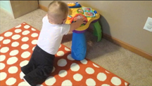 baby kneeling at play table